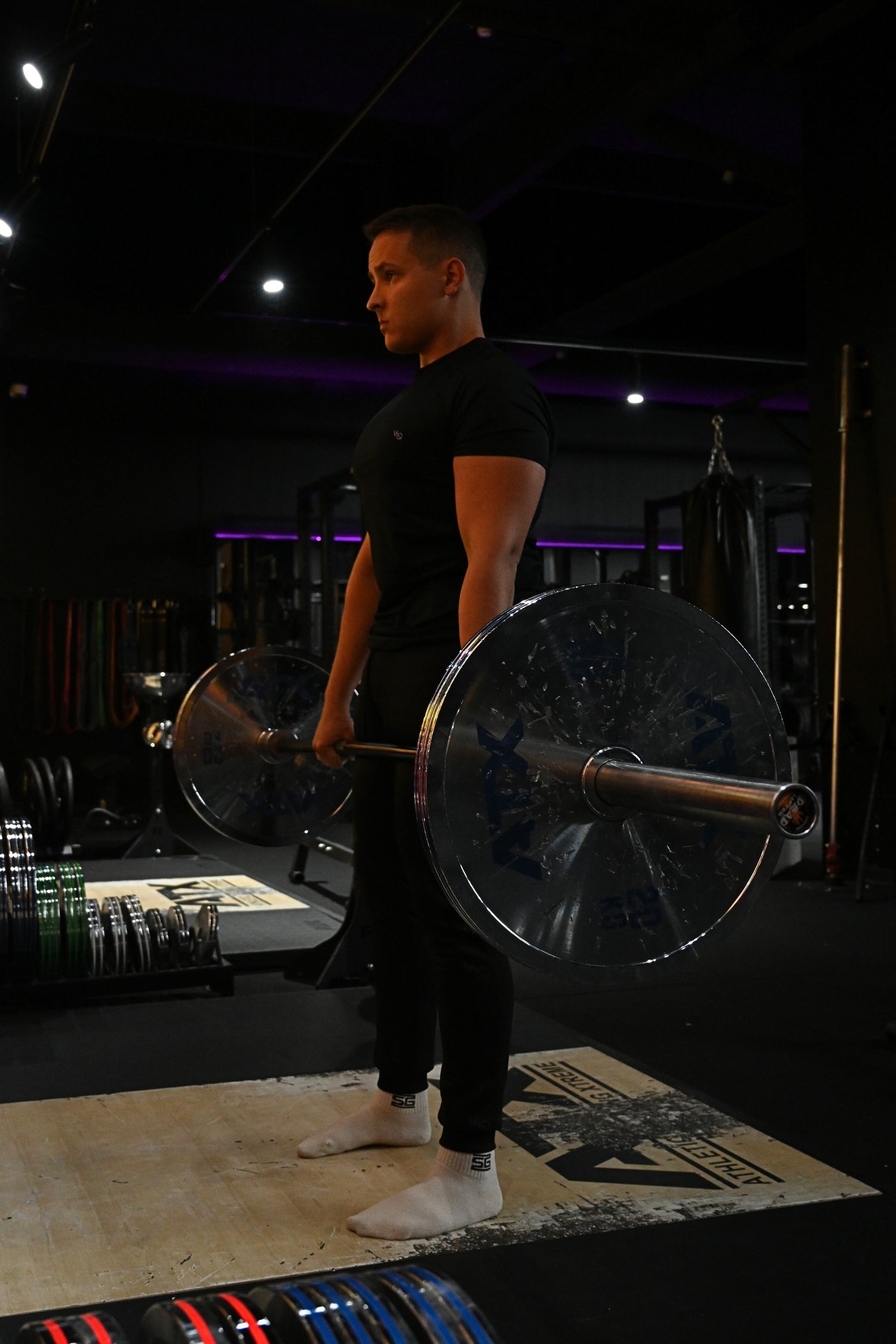 Henkilö suorittaa painonnostoliikettä kuntosalilla vahvistaakseen koko kehoa.